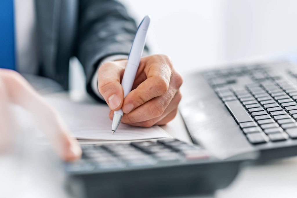 Office worker writing on notepad