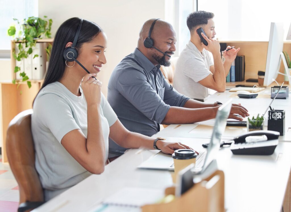 A team of professionals in an office wearing headsets while working together on their tasks.