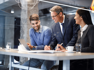 Work colleagues at a desk smiling