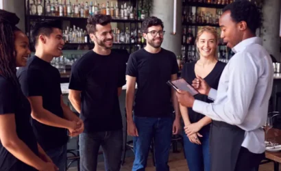 A group of individuals standing together in a bar, engaged in conversation and enjoying their time.