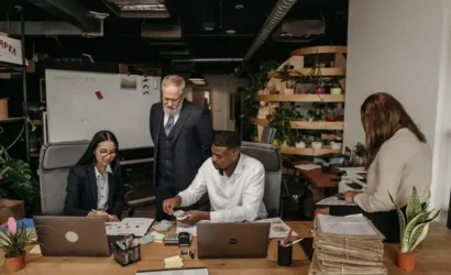 A diverse group of professionals collaborating on projects in a modern office setting.