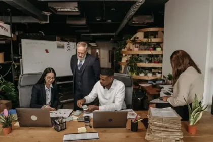 A diverse group of professionals collaborating on projects in a modern office setting.