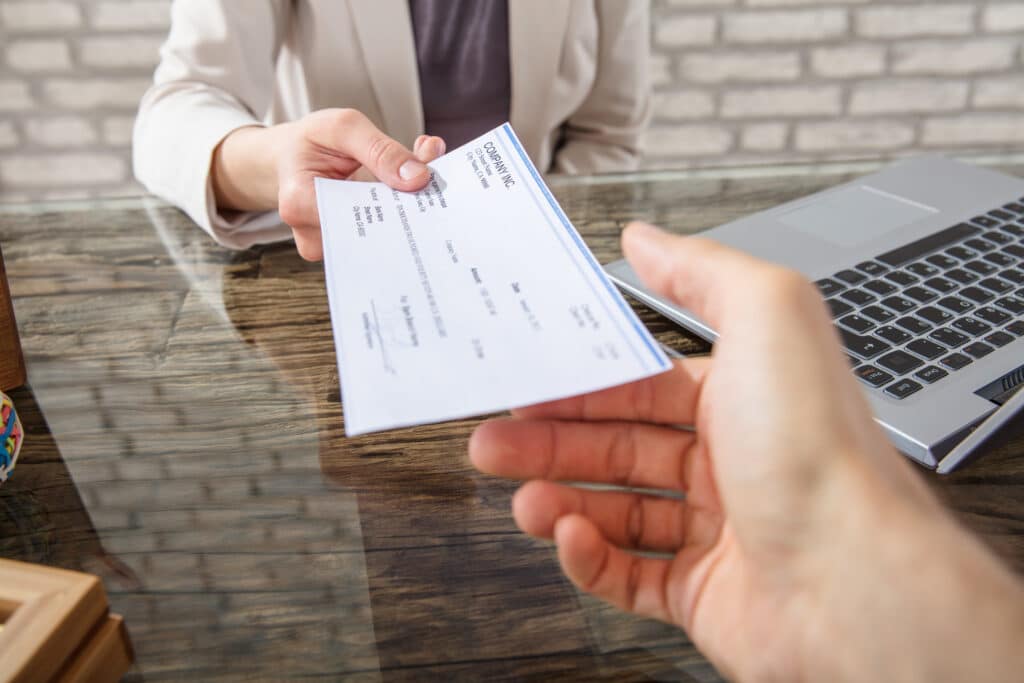 employer handing a payslip to an employee